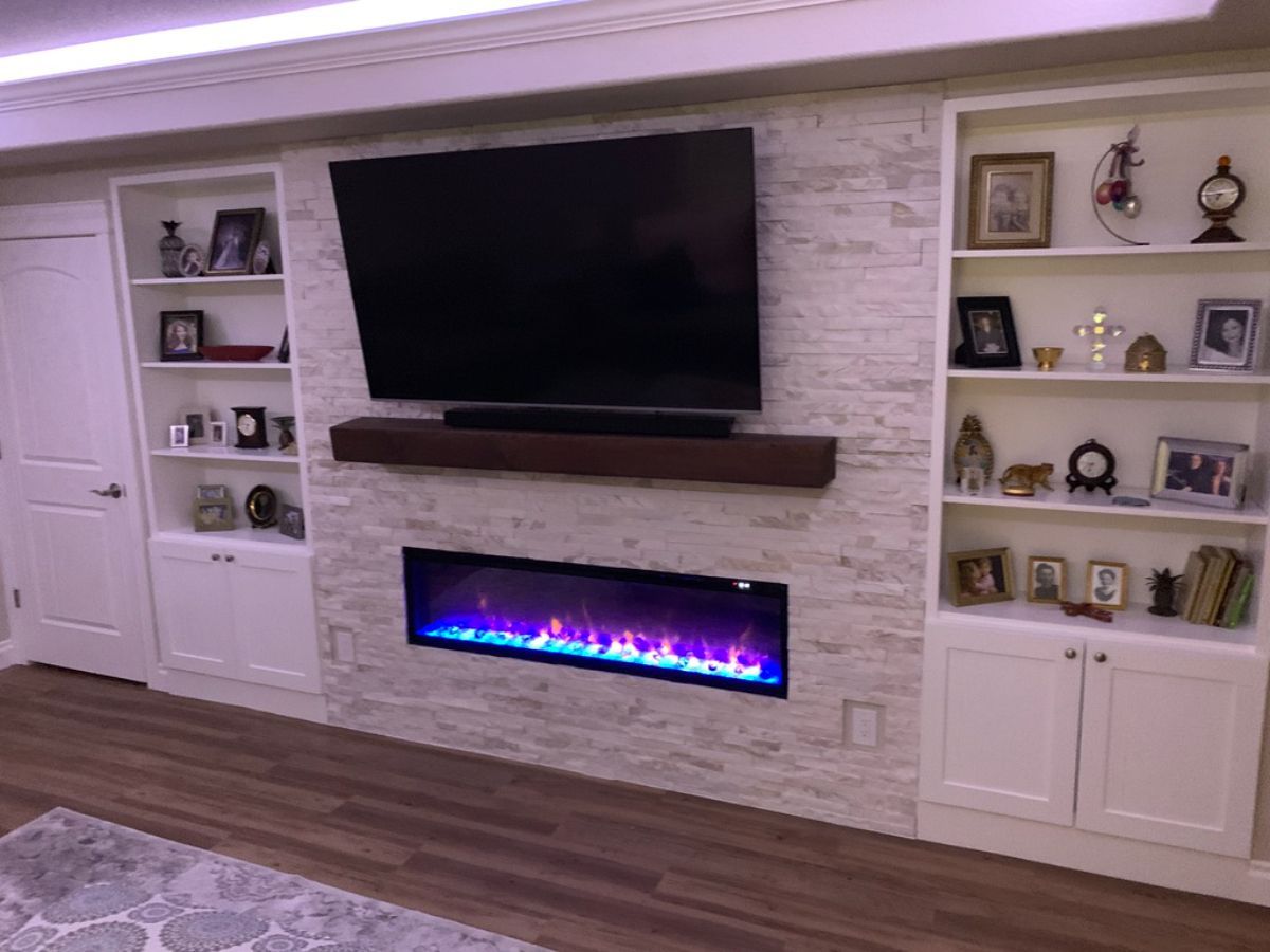 a living room with a fireplace and a flat screen tv on the wall .