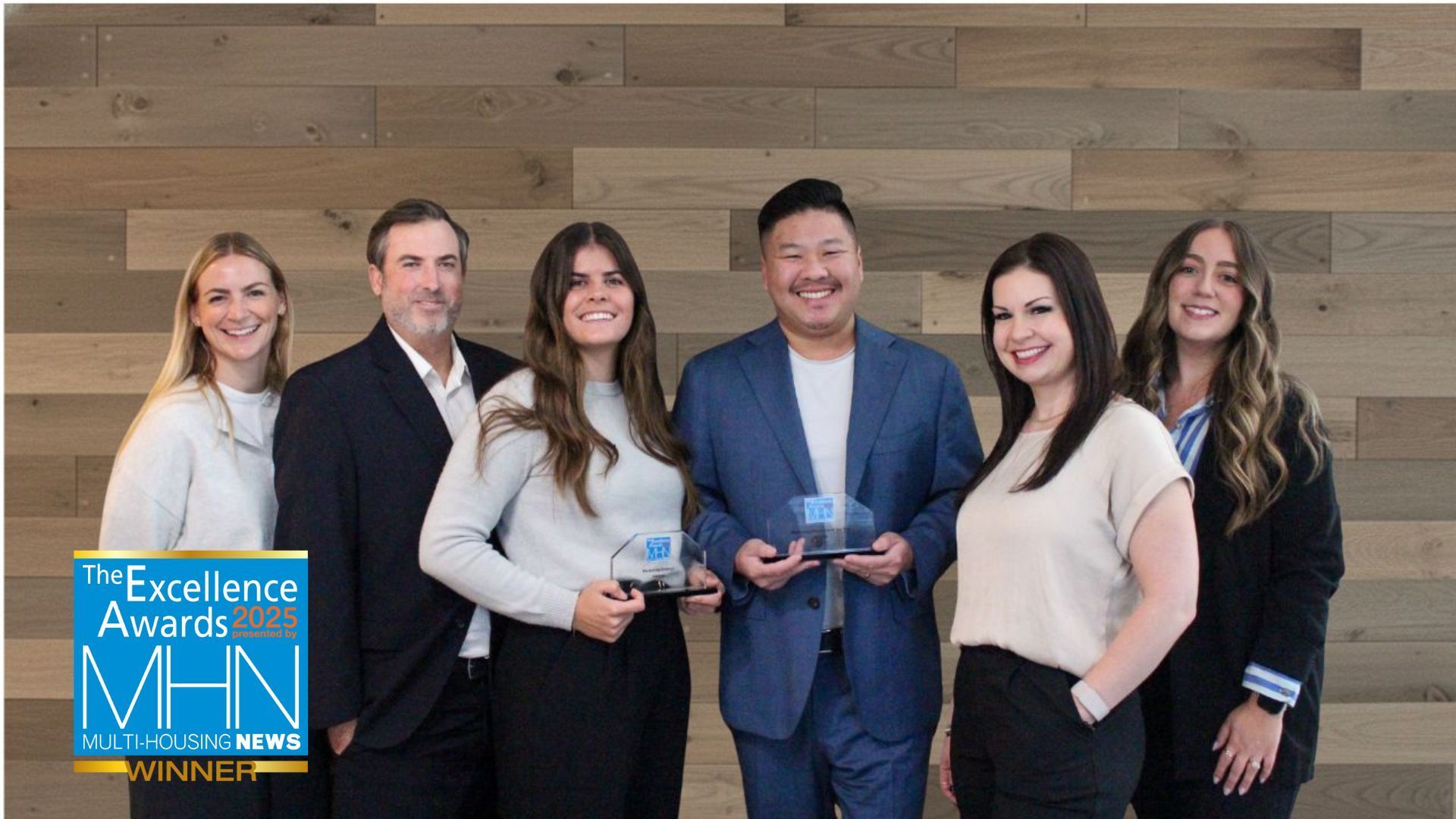 Five people posing with an award outdoors, in front of a building. MHN Excellence Awards winner logo