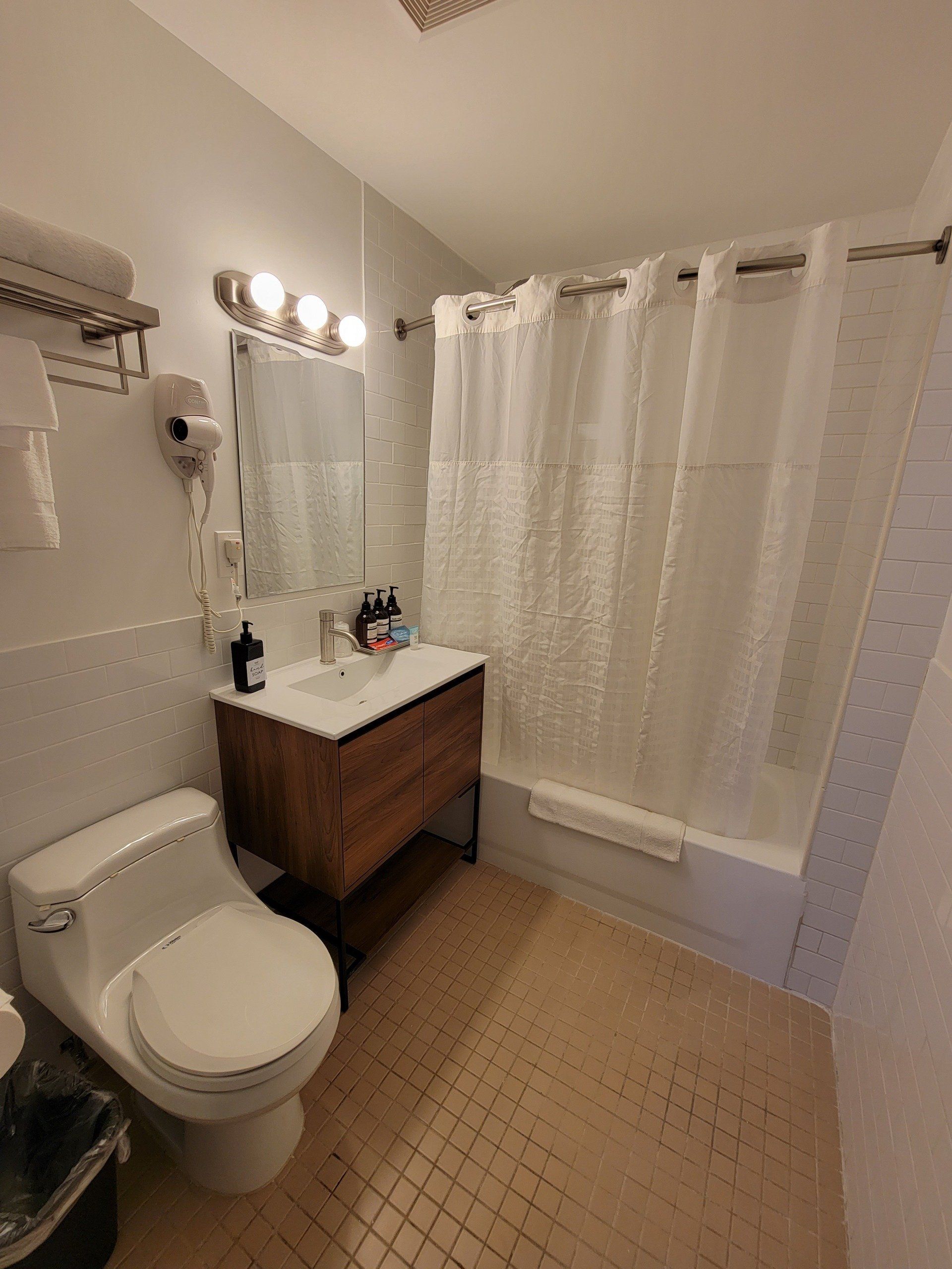 A bathroom with a toilet , sink , and shower.