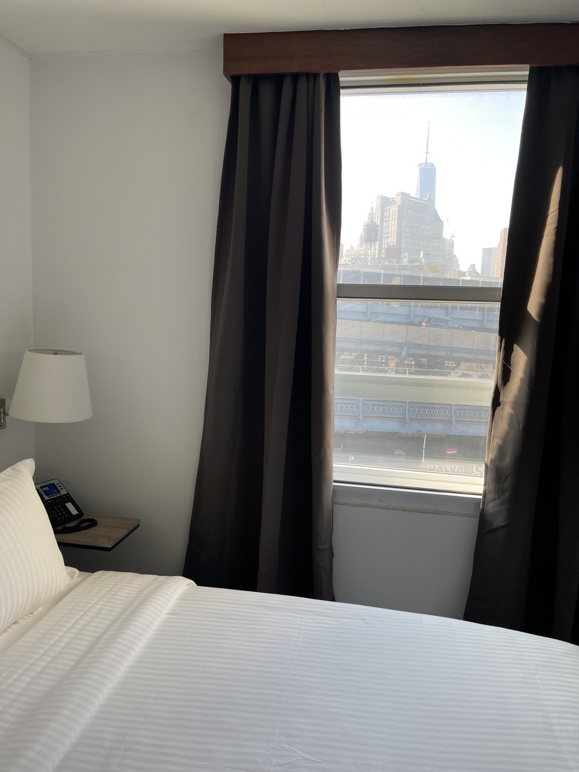 A hotel room with a bed and a window
