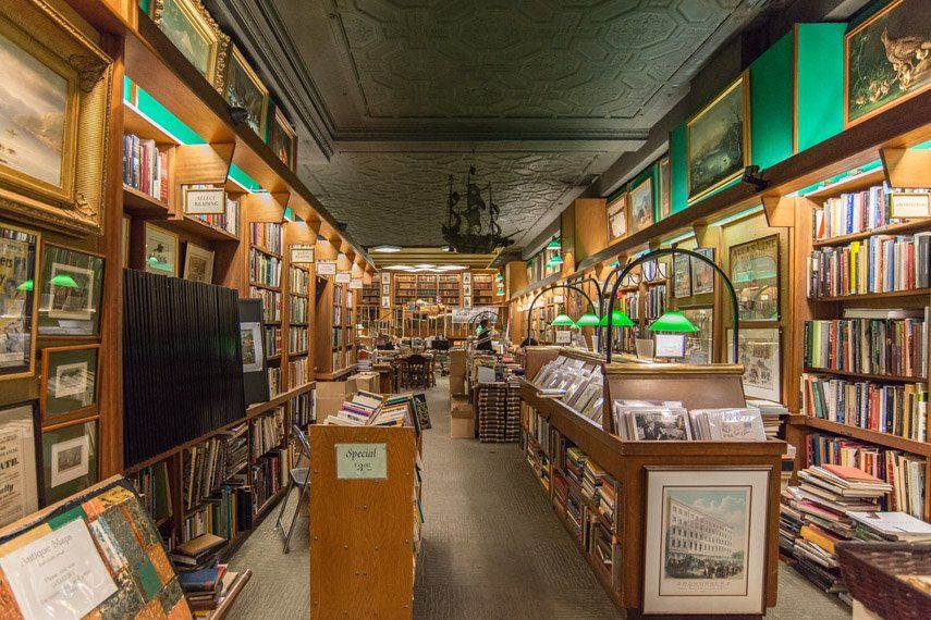 A book store filled with lots of books and paintings