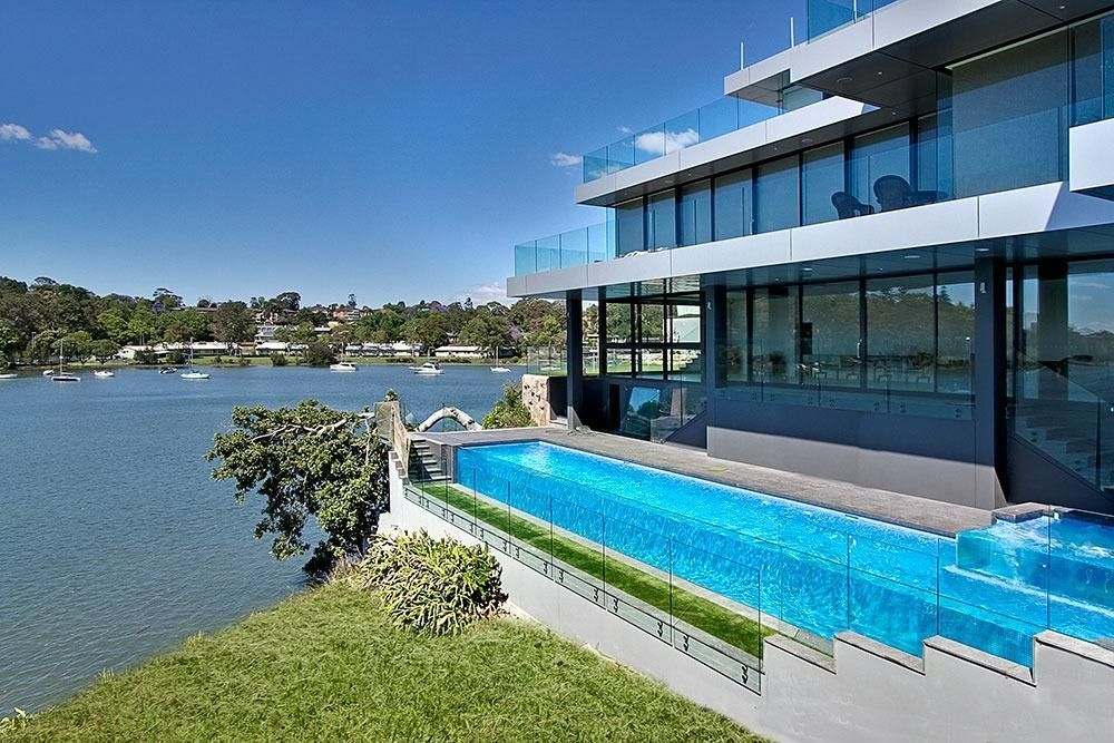 A Large House With A Swimming Pool Overlooking A Lake — Dimension One Glass Fencing In Tuggerah, NSW
