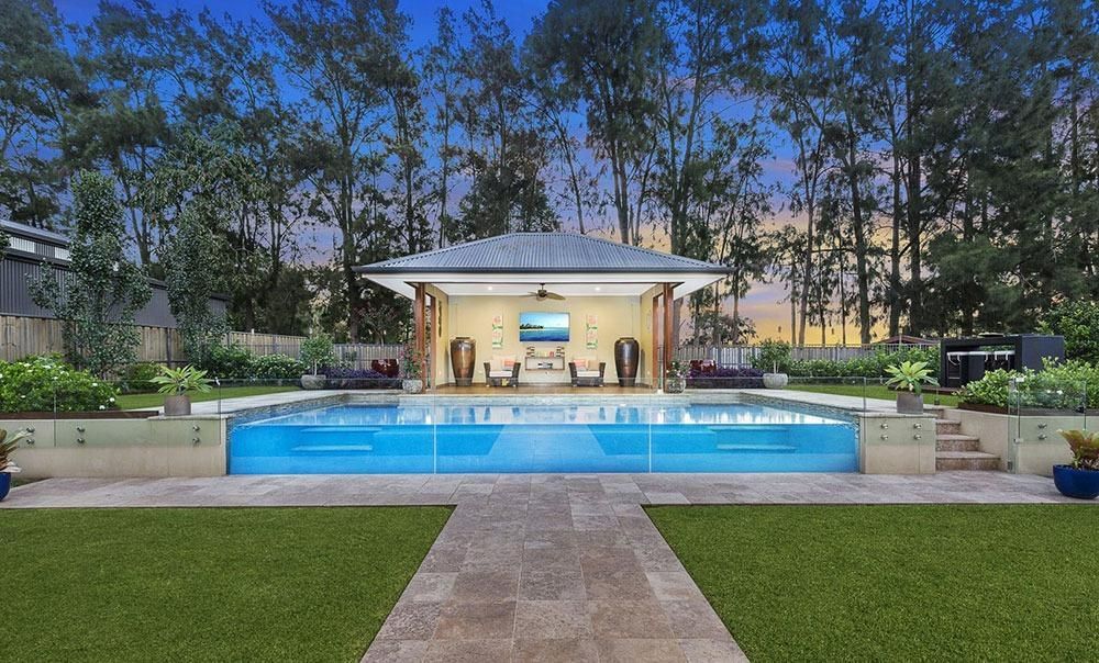 A Large Swimming Pool With A Gazebo In The Backyard — Dimension One Glass Fencing In Tuggerah, NSW