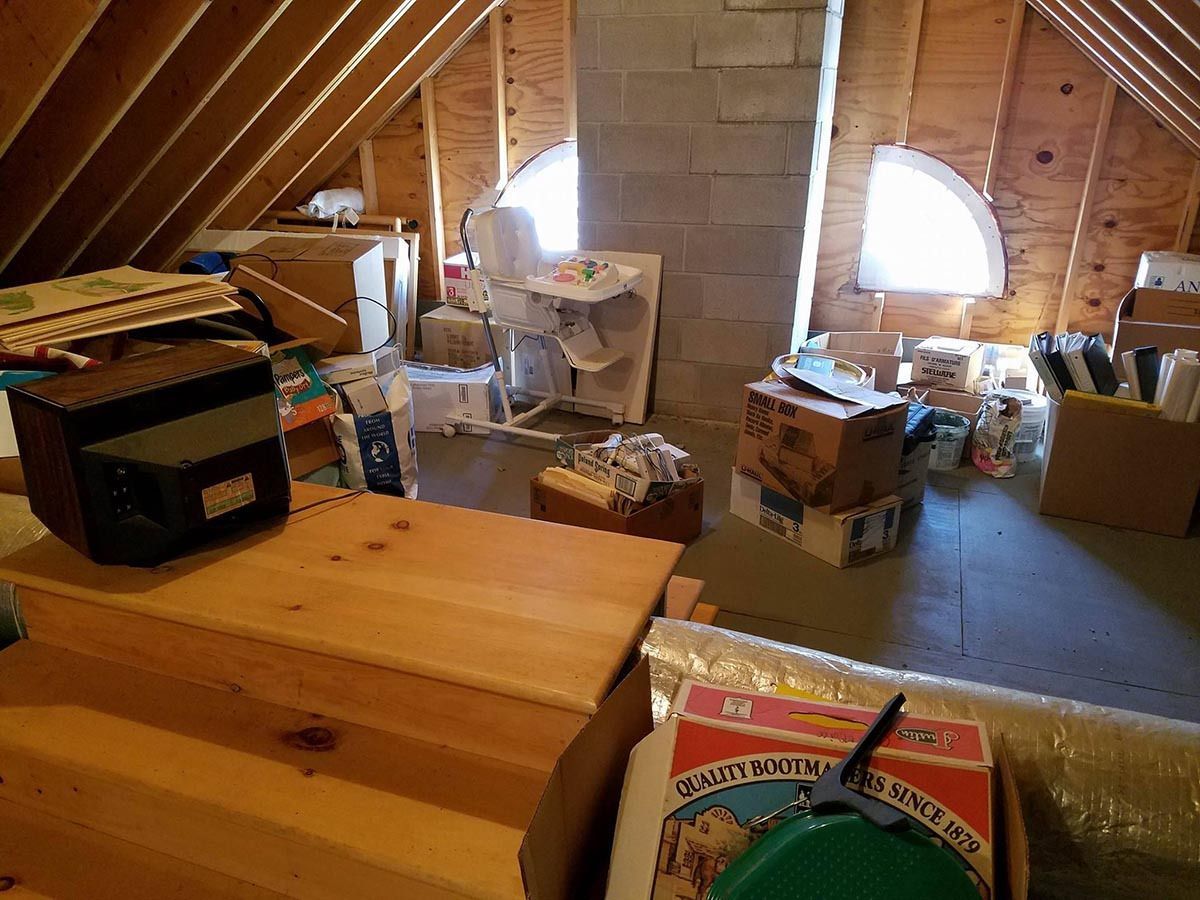 An attic filled with boxes and a radio.