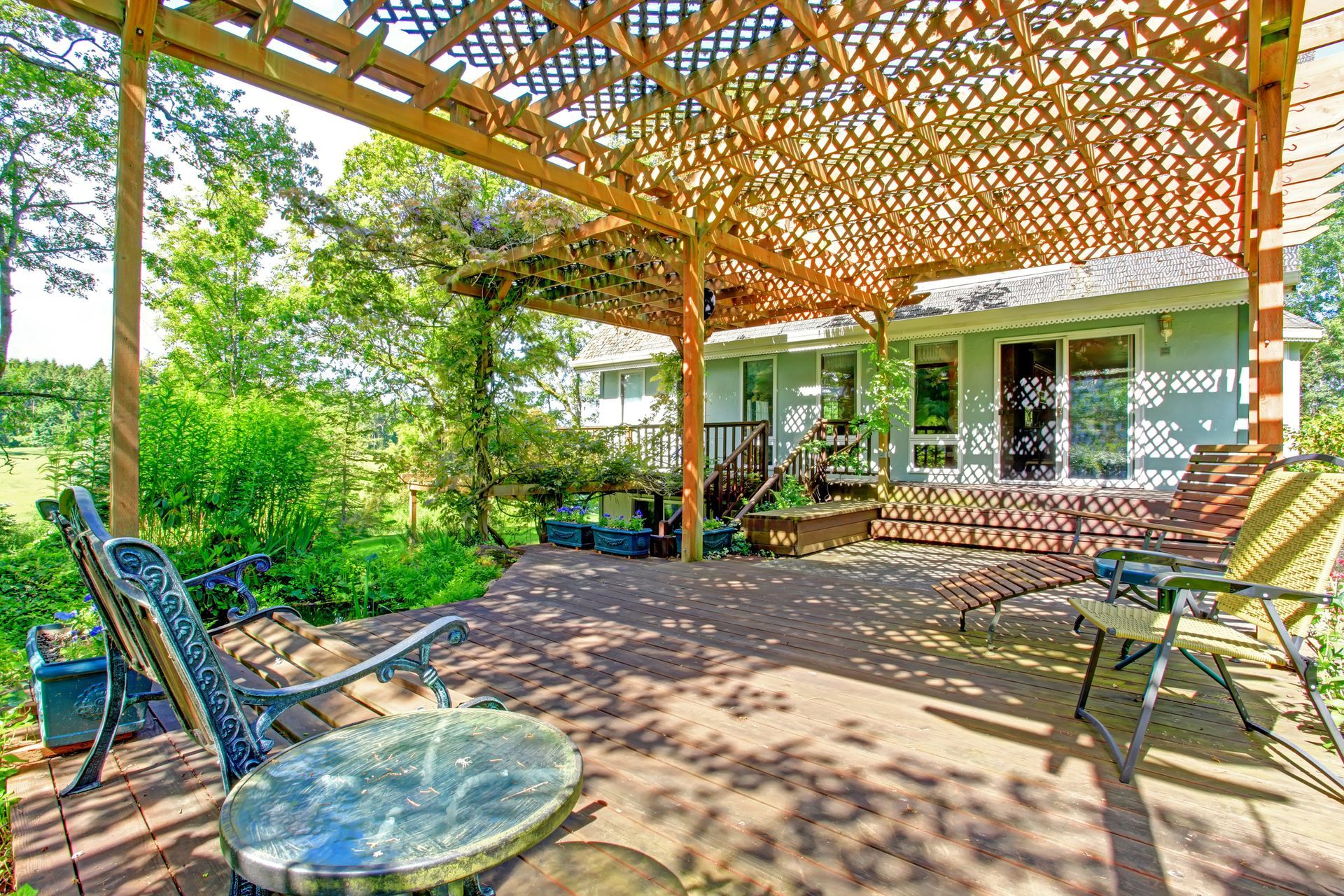 A patio with a table and chairs under a pergola. A patio with a table and chairs under a pergola.