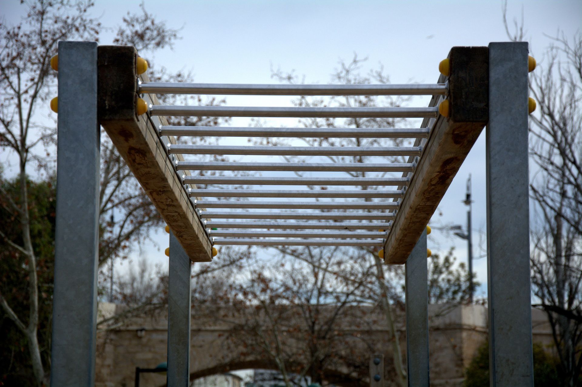 A metal and wooden structure with a bridge in the background A metal and wooden structure with a bridge in the background