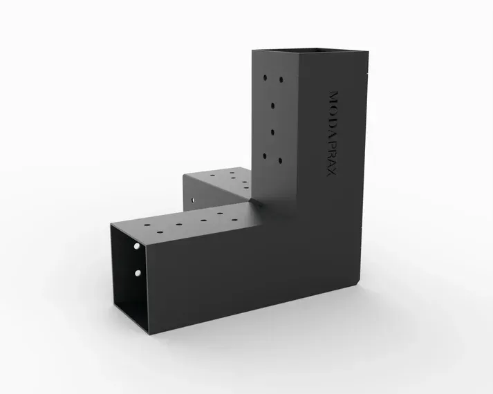 A black metal block with holes in it is sitting on a white surface.