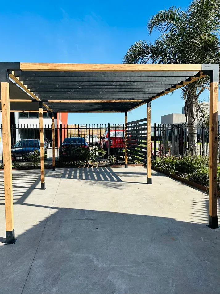 A pergola is sitting in the middle of a parking lot