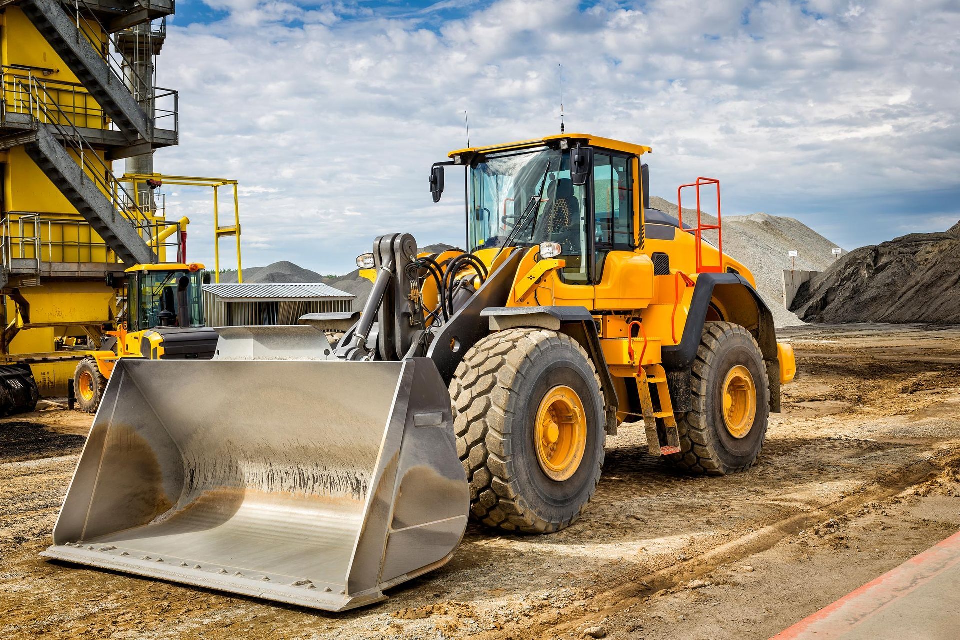 A yellow bulldozer is parked on a construction site.