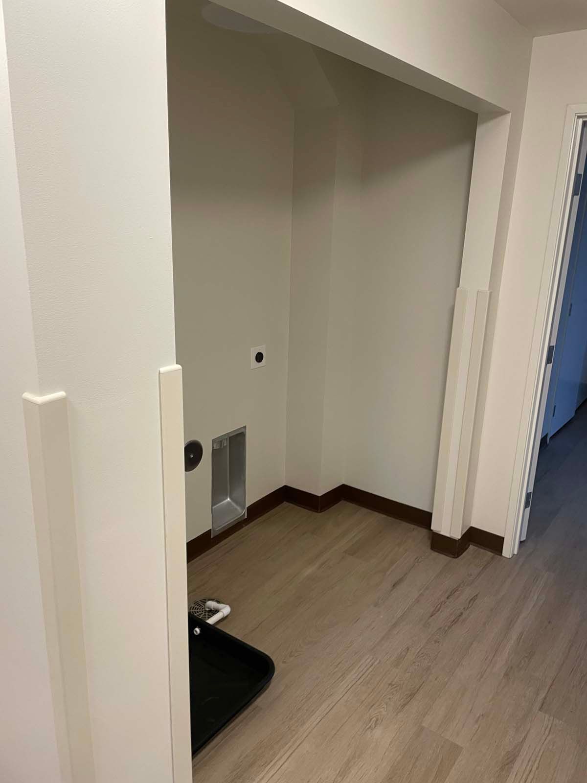 Empty closet or alcove with light wood flooring, beige walls, and a floor vent.