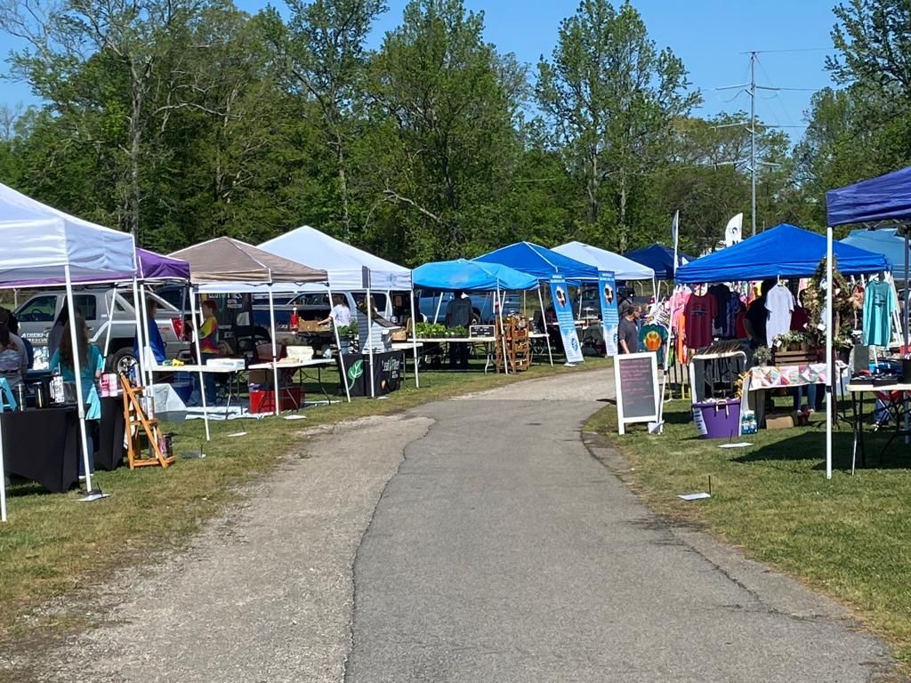 There are many tents and tables on the side of the road.
