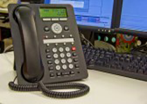 a telephone is sitting on a desk next to a computer .