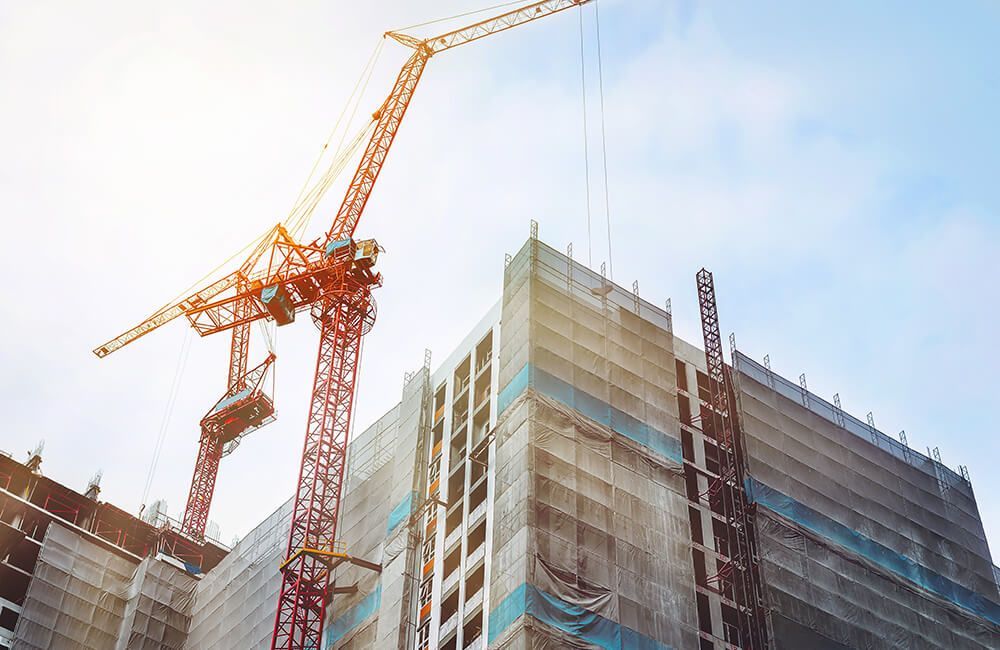 A large building is being built with cranes and scaffolding.