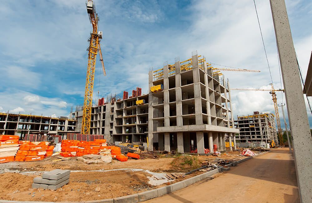 A construction site with a lot of cranes and buildings under construction.