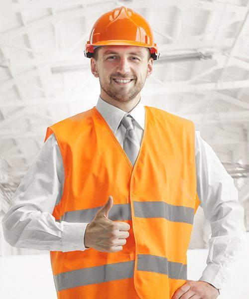 A man wearing an orange vest and hard hat is giving a thumbs up