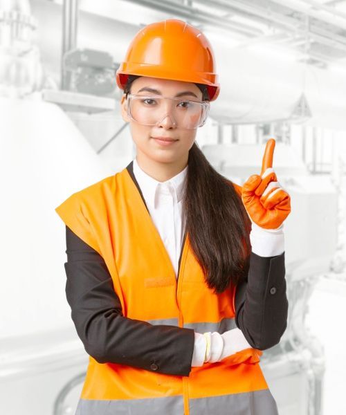 A woman wearing a hard hat and safety vest is pointing up.