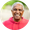 Smiling person in a bright pink hoodie against a blurred outdoor background