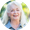 Smiling woman with long white hair outdoors against a blurred green background