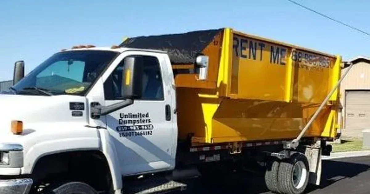 Unlimited Dumpsters roll off truck delivering a yellow dumpster for a contractor job site in Central