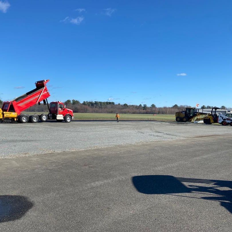 A red dump truck is parked on the side of the road.