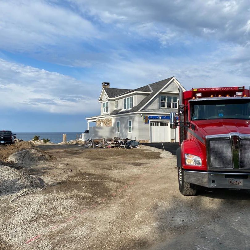 A red truck is parked in front of a house
