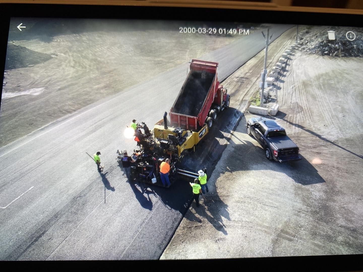 An aerial view of a truck being loaded with asphalt