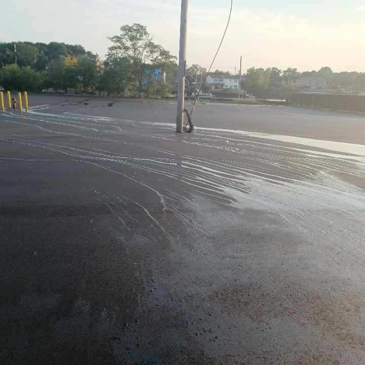 A parking lot with a hose hanging from a pole.