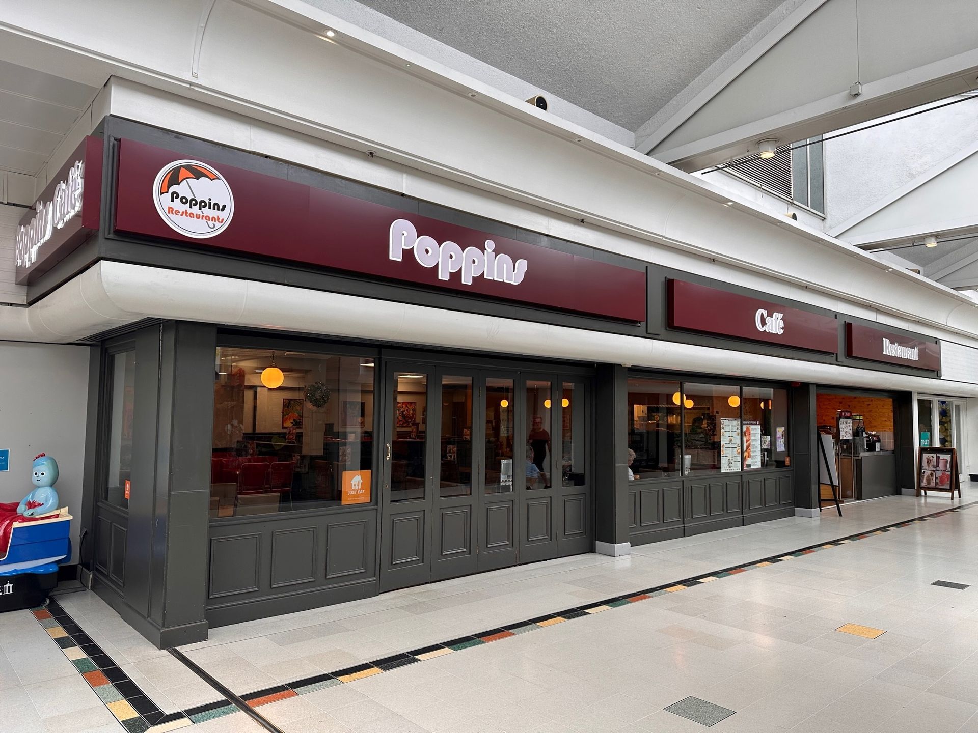 Pepperl restaurant storefront with dark red signage and glass doors in a covered shopping area