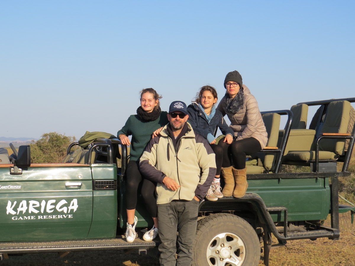 Family posing on safari jeep in Kariega Game Reserve, South Africa.