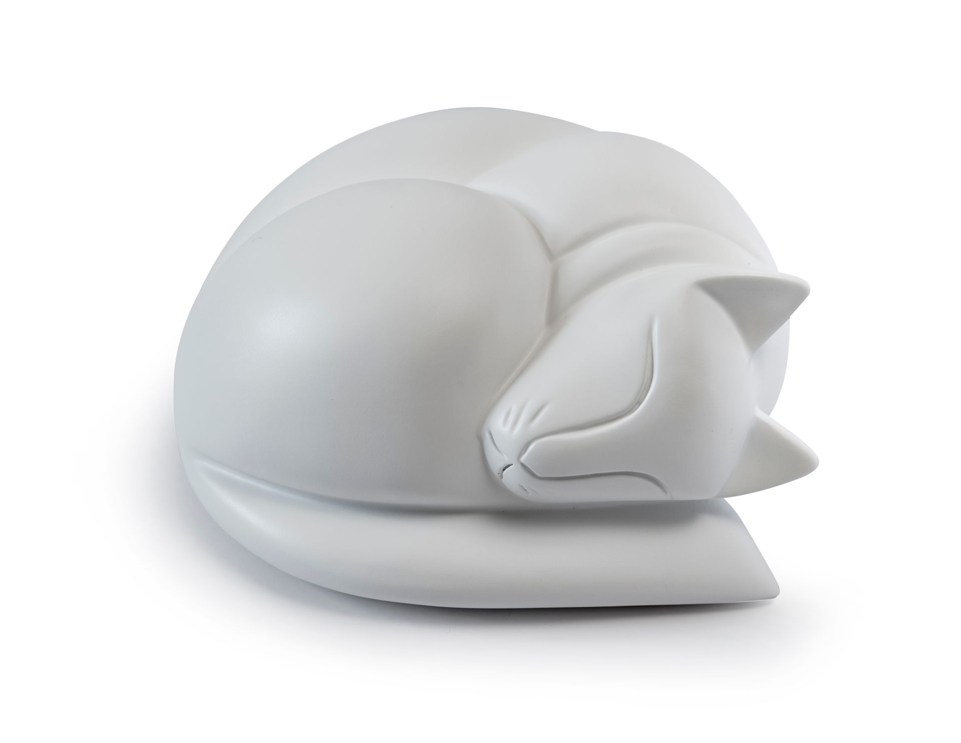 White curled sleeping cat figurine on a soft gray cushion