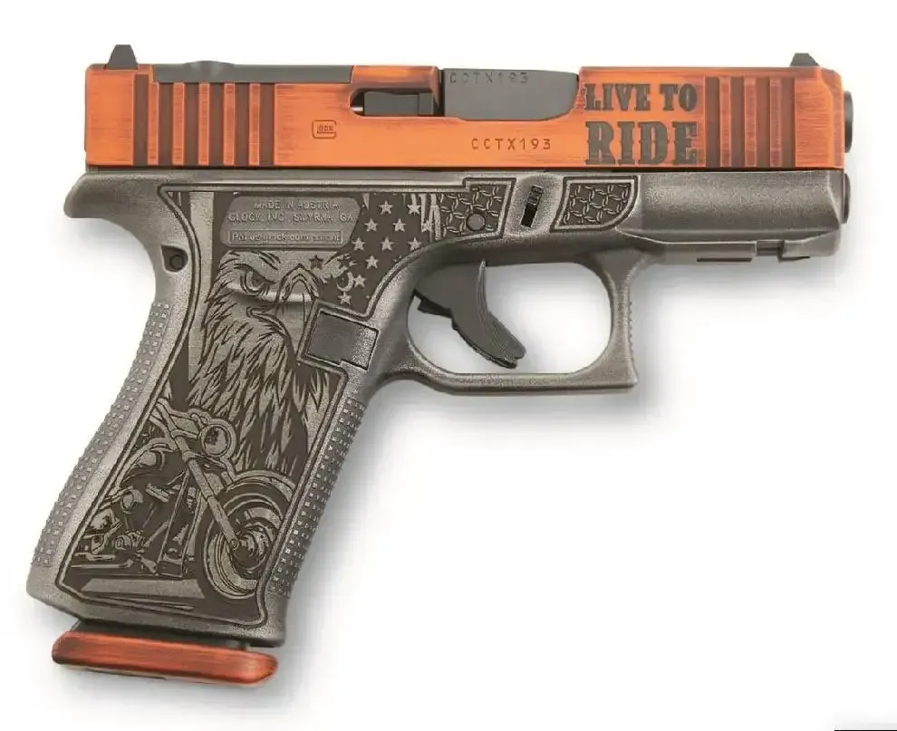 Orange-and-black handgun with ornate grip and “LIVE TO RIDE” text on slide, shown on white background