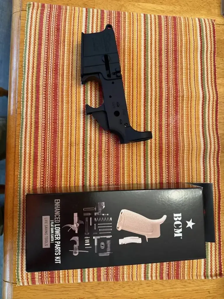 Black handgun-shaped object above a black box on a striped woven mat.