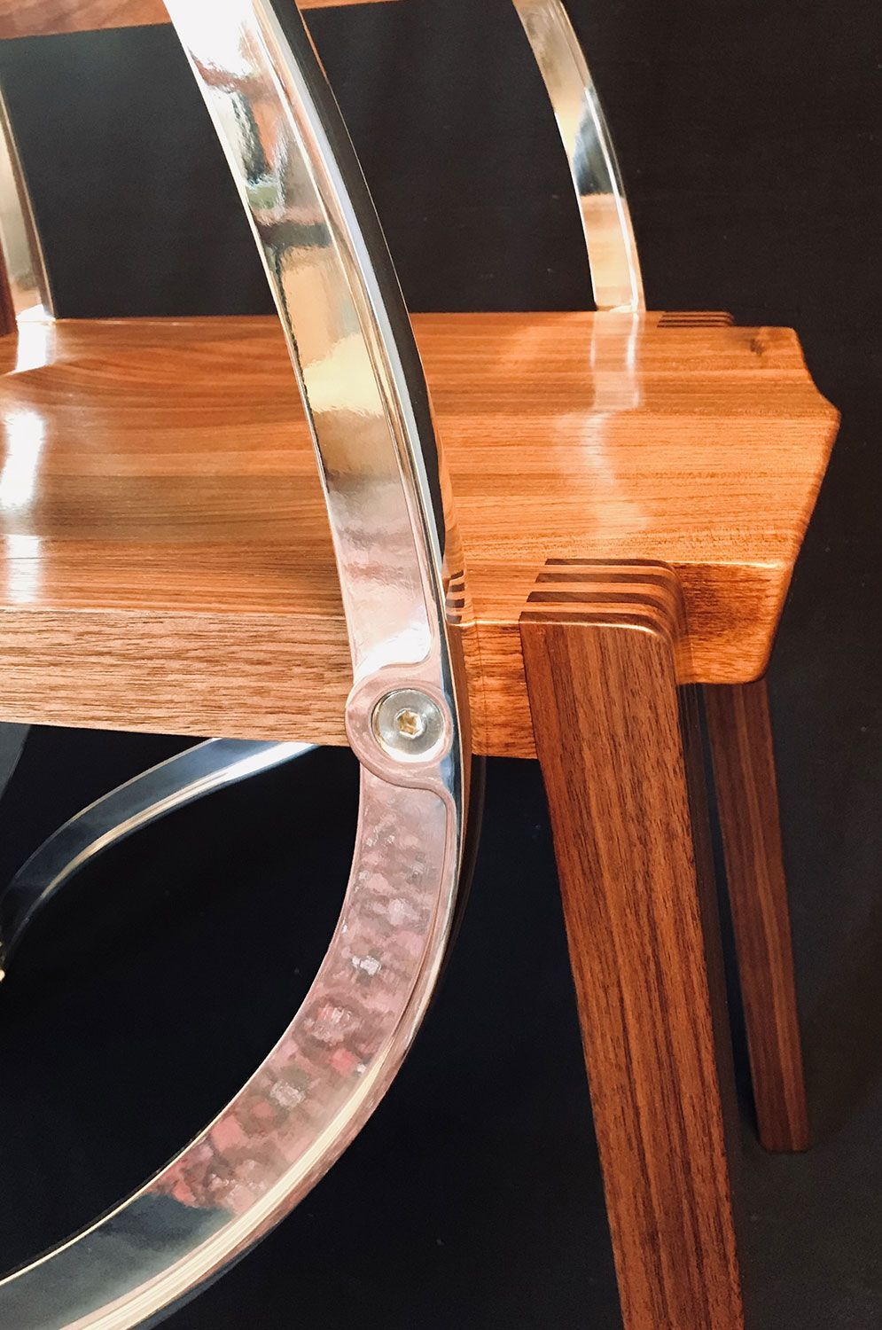 A close up of a contemporary wooden chair with a metal frame