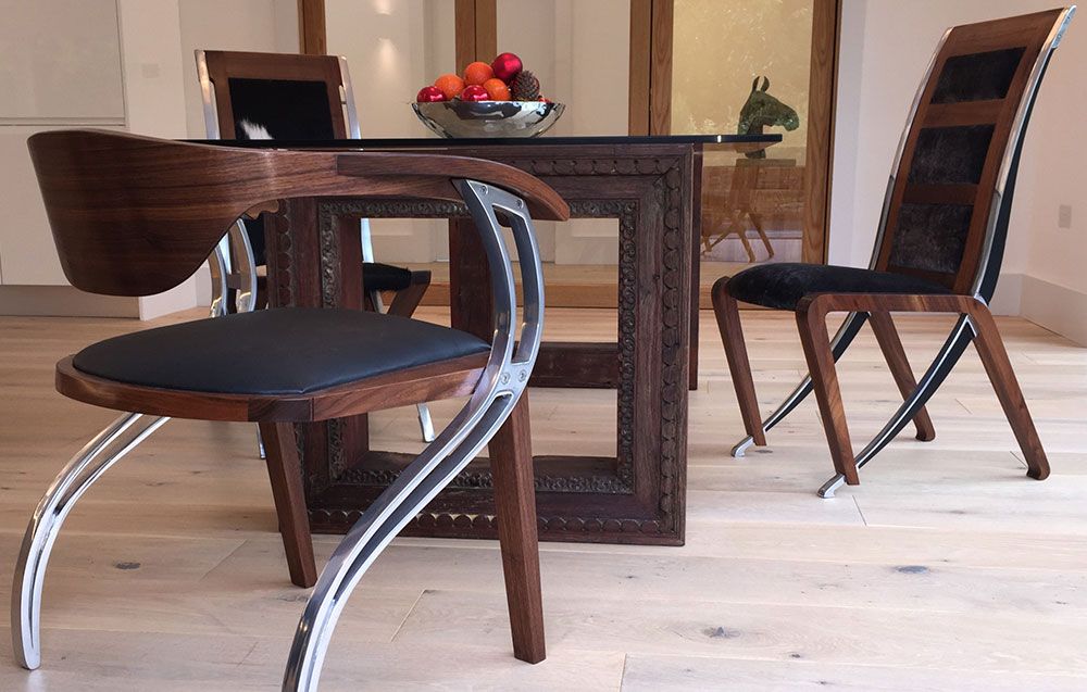 A custom built dining room table and dining chairs with a bowl of fruit on it