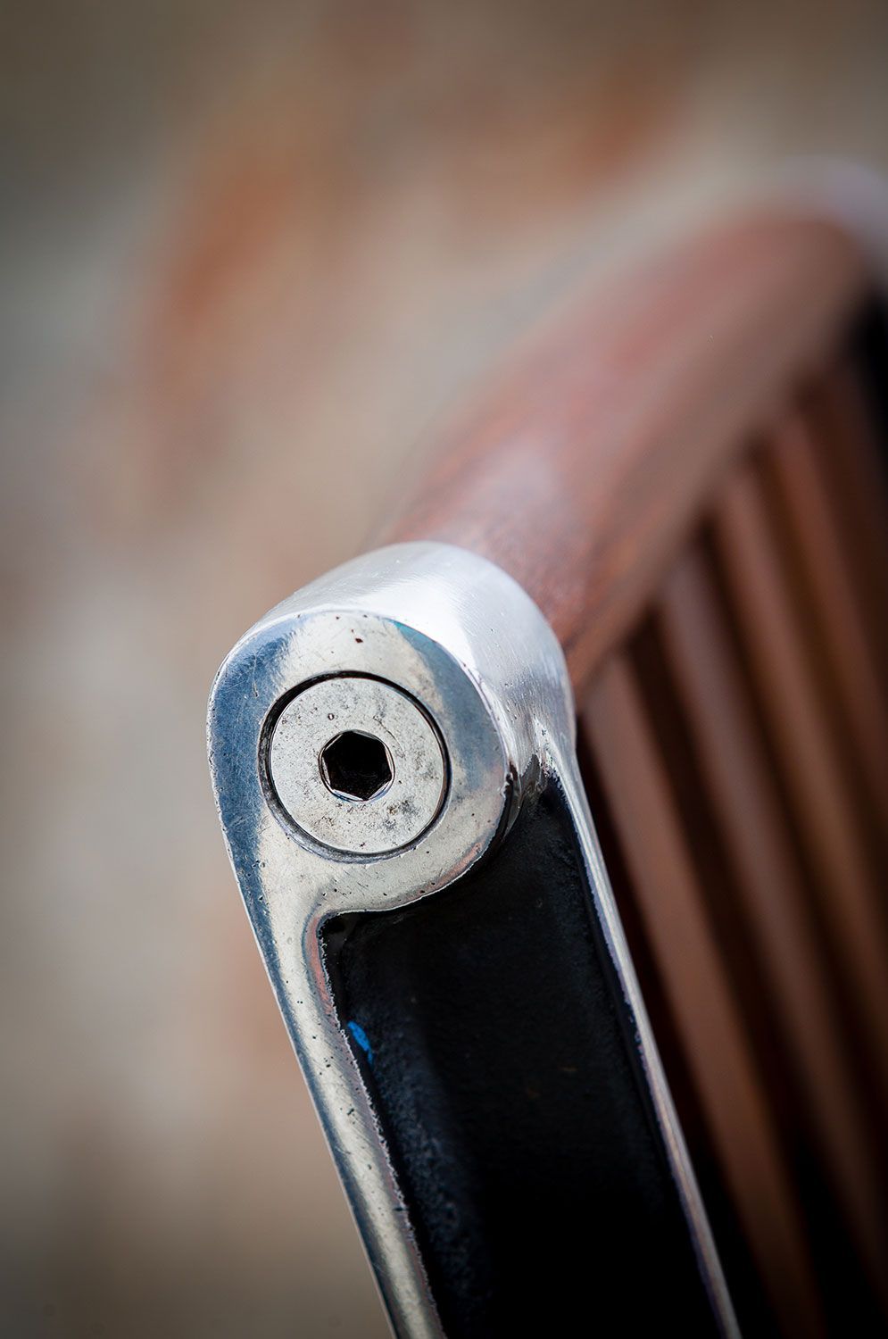A close up of a designer walnut dining chair with high end metal cast