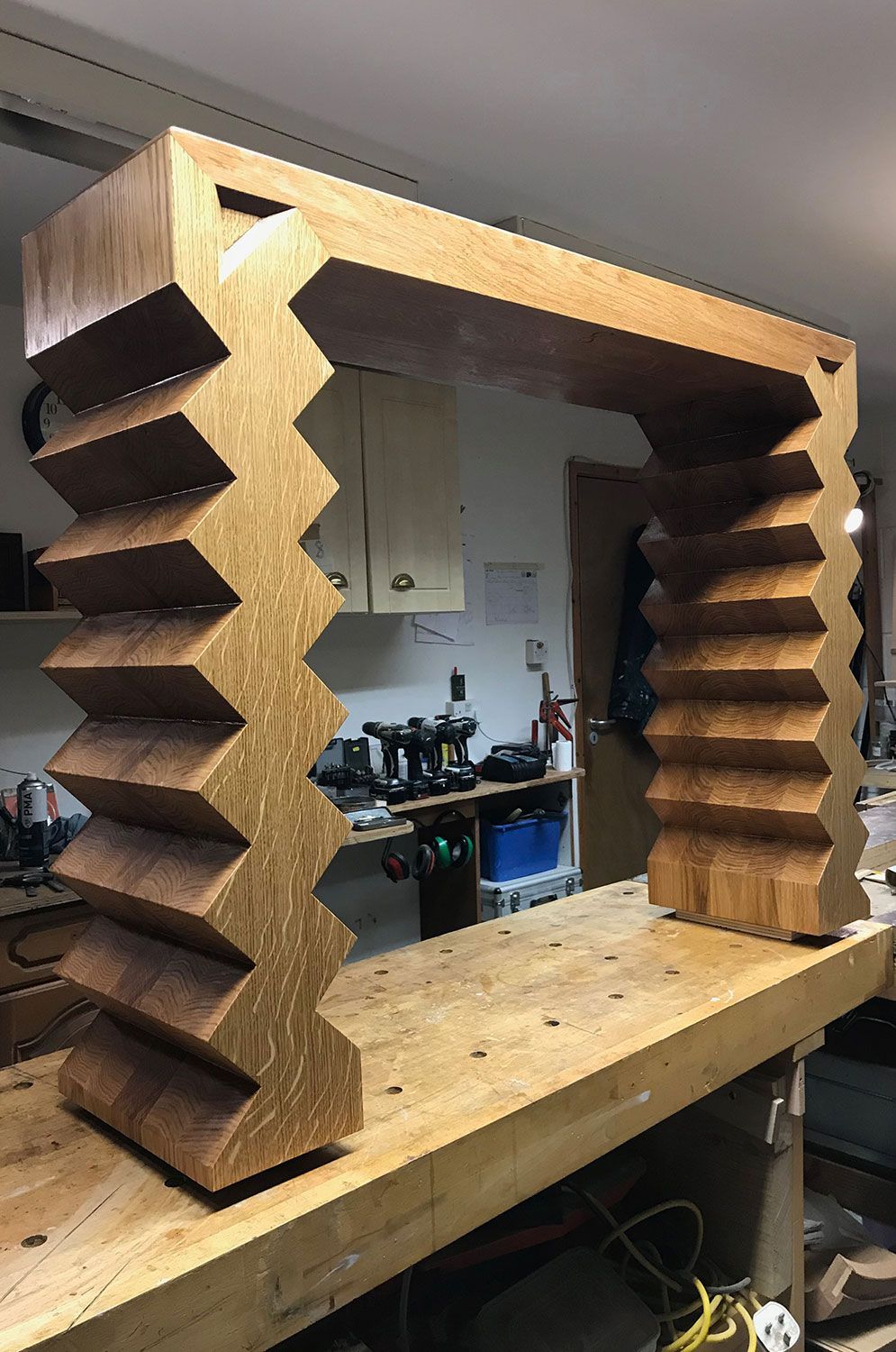 A one of a kind wooden console is sitting on top of a wooden table.
