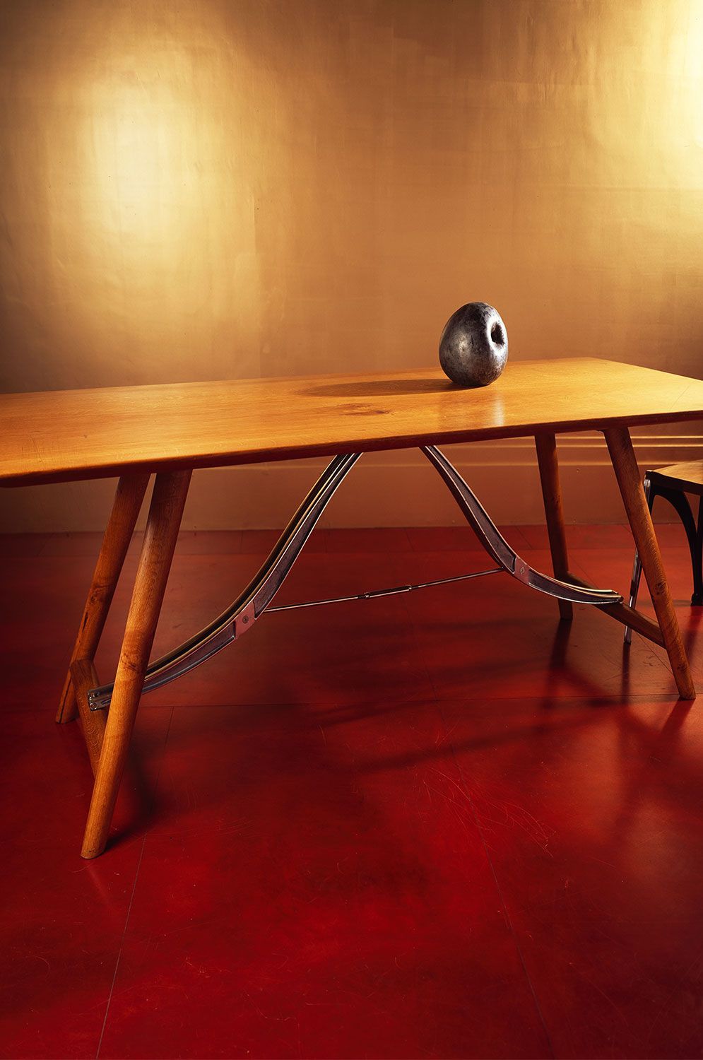 A handcrafted oak wooden table with a ball on top of it.