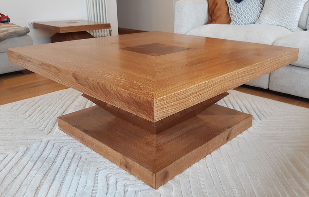 A contemporary coffee table set is sitting on top of a white rug in a living room.