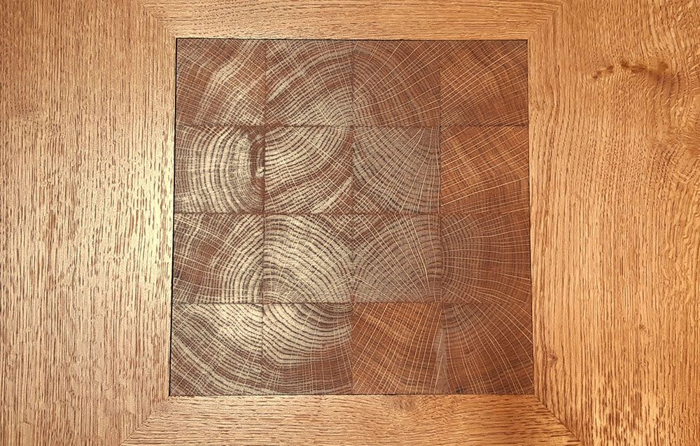 A close up of a piece of bespoke wood with a square in the middle.