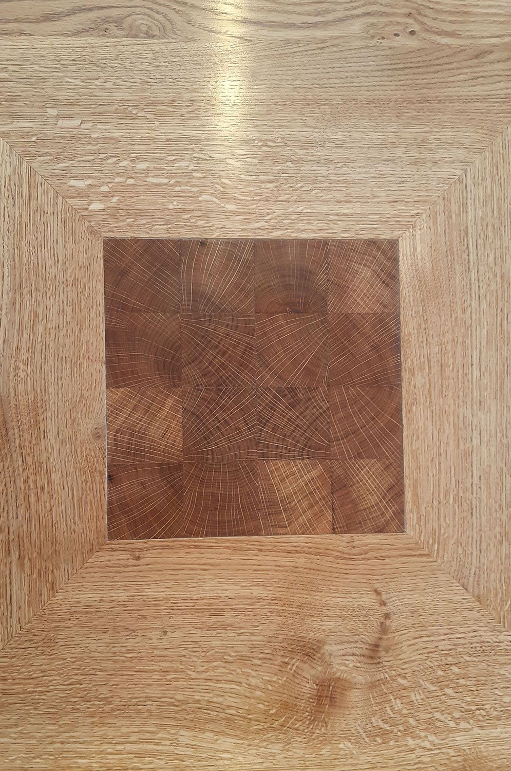 A close up of a piece of wood work with a square in the middle.