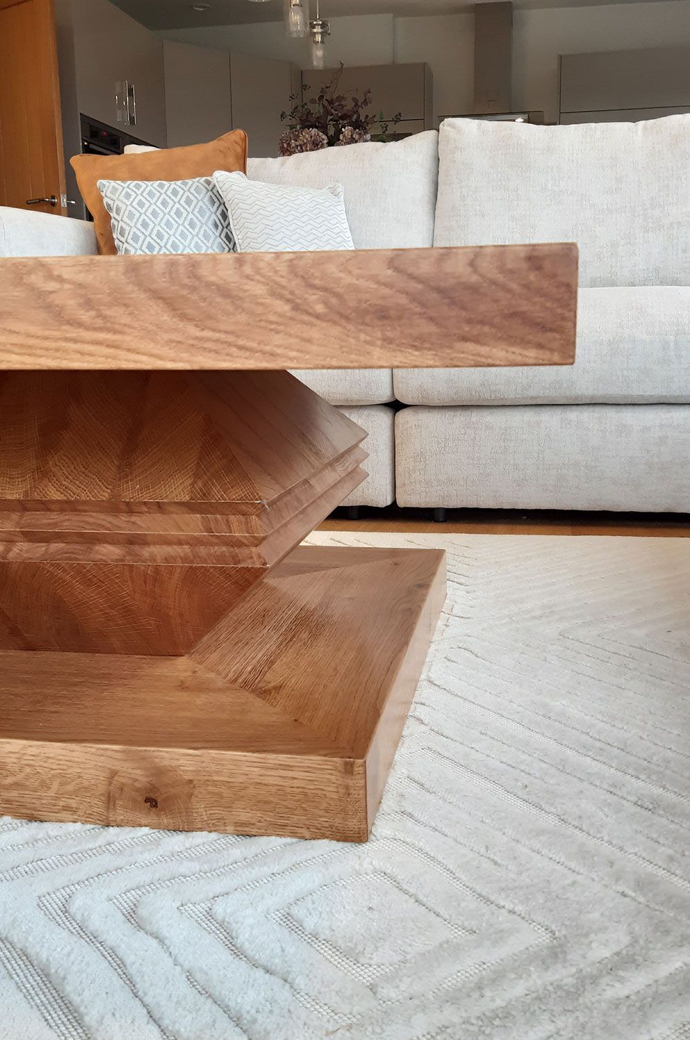A wooden coffee table is sitting in a living room next to a white couch.