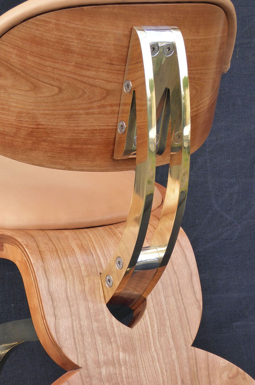 A close up of a custom wooden chair with a metal arm rest