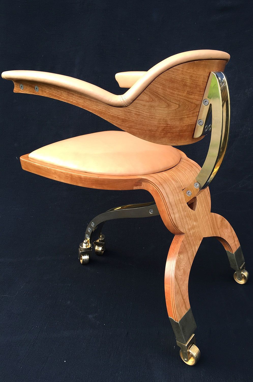 A unique designer wooden office chair with wheels on a black surface