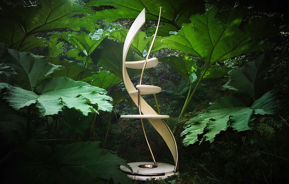A one of a kind wooden sculpture is sitting in the middle of a forest.