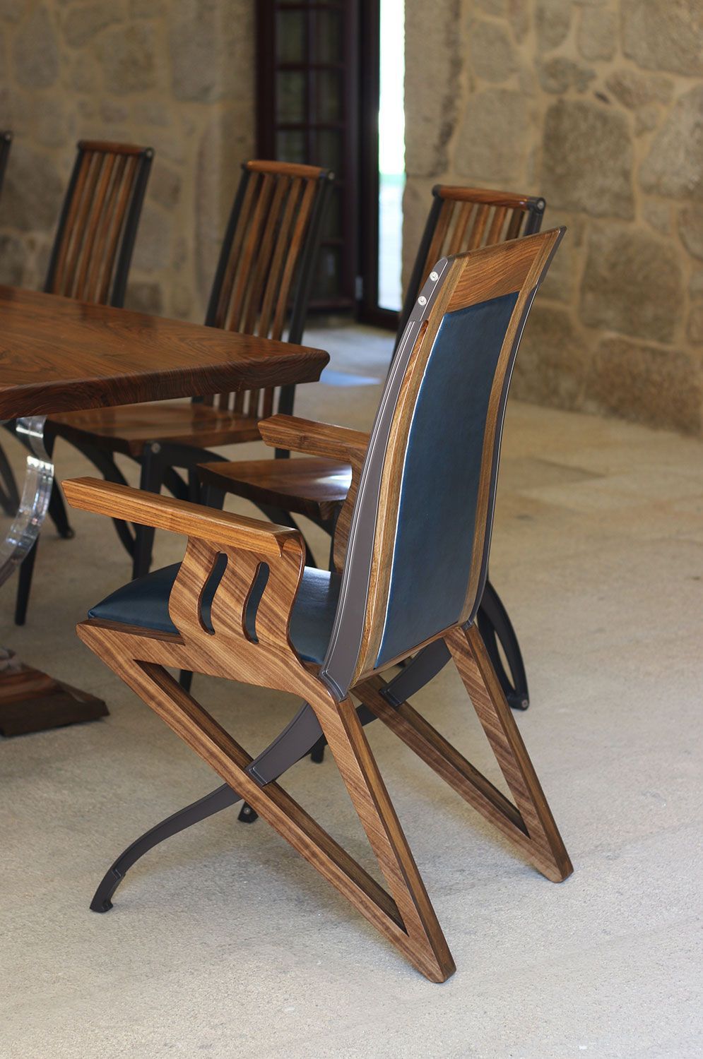 The pegasus chair wooden chair is sitting next to a table in a room.