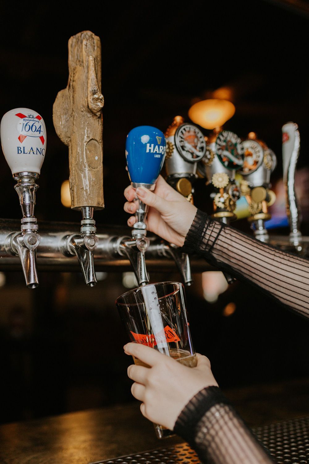 A person is pouring beer from a tap into a glass.