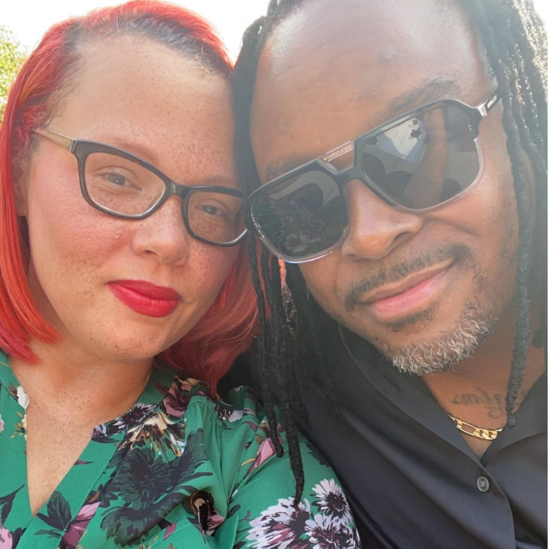 A man and a woman wearing sunglasses are posing for a picture
