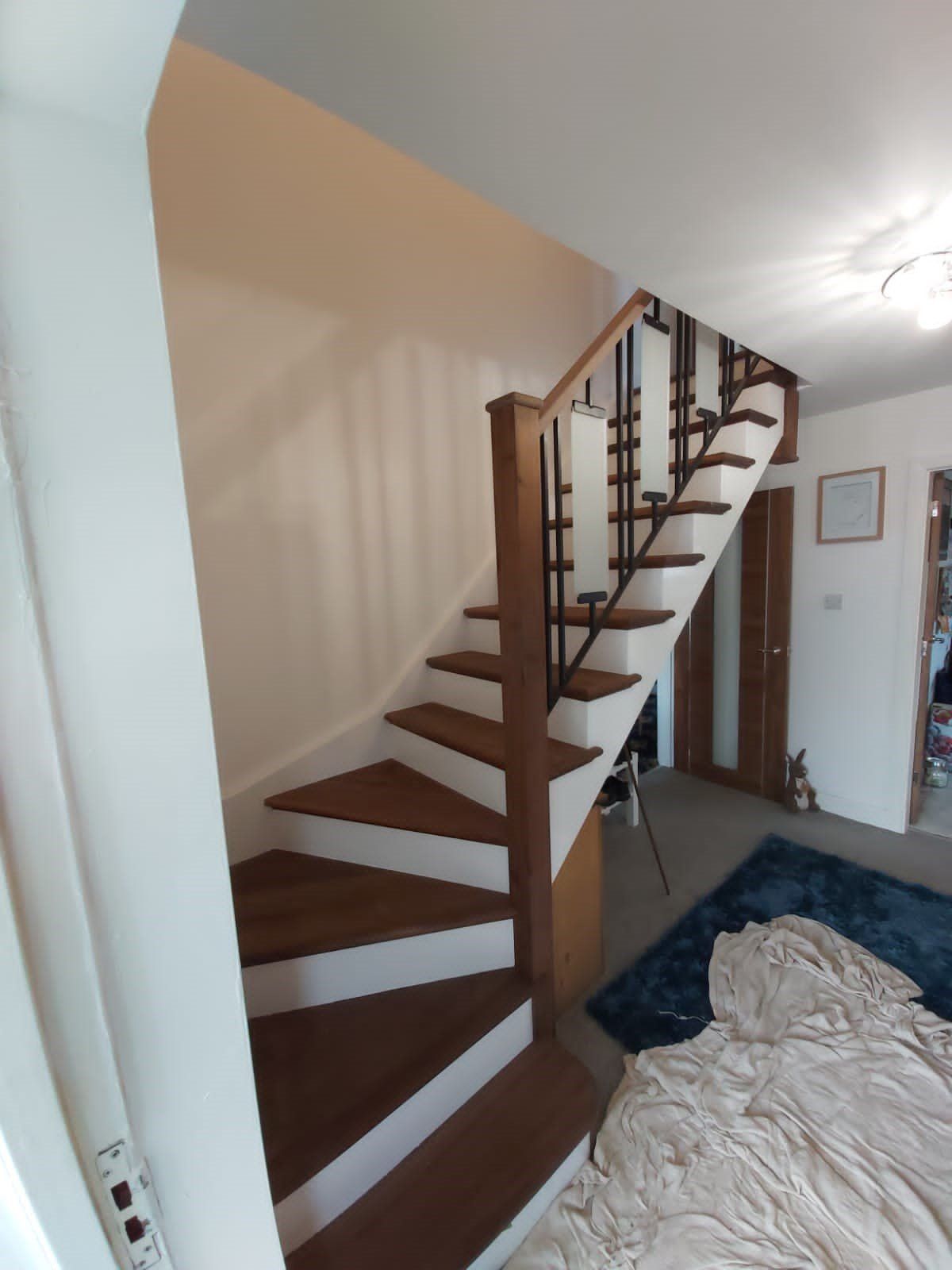 Wooden staircase with white risers and brown treads, leading upwards.