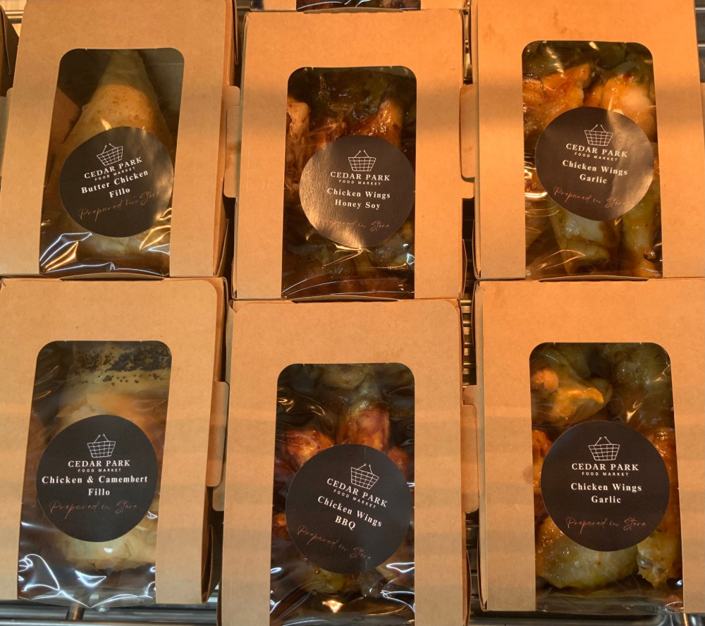 Packaged cooked chicken products displayed in takeaway boxes — Cedar Park Supermarket In Taranganba, QLD