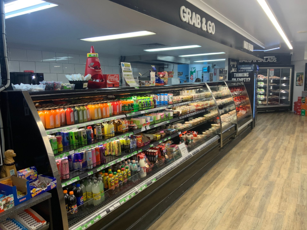 Convenience store grab-and-go aisle with drinks and snacks under bright overhead lights— Cedar Park Supermarket In Taranganba, QLD